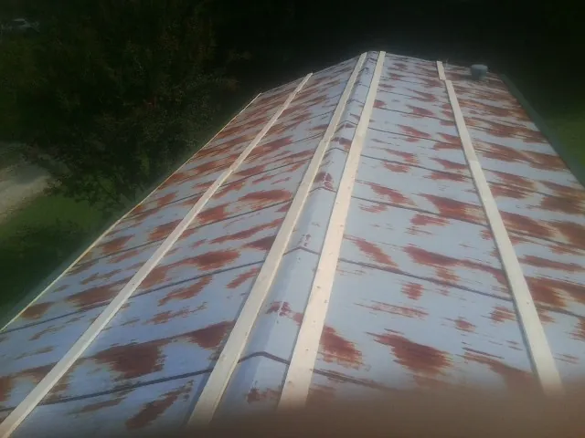 Rusted metal roof panels with new wood purlins before replacement — Storm Damage Roof Repair in Bakersville by Roofing Brothers
