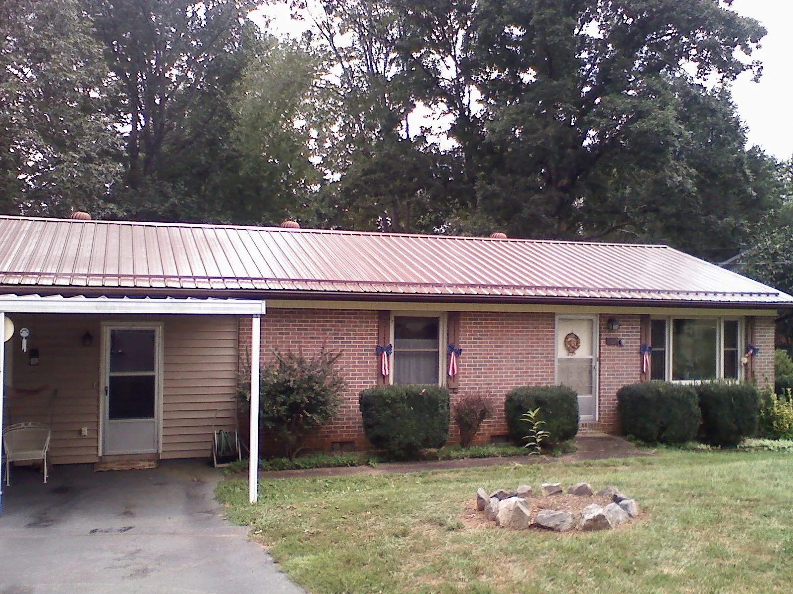 Bronze metal roof and carport on a brick ranch home — Roof Repair work by our crew in Bakersville