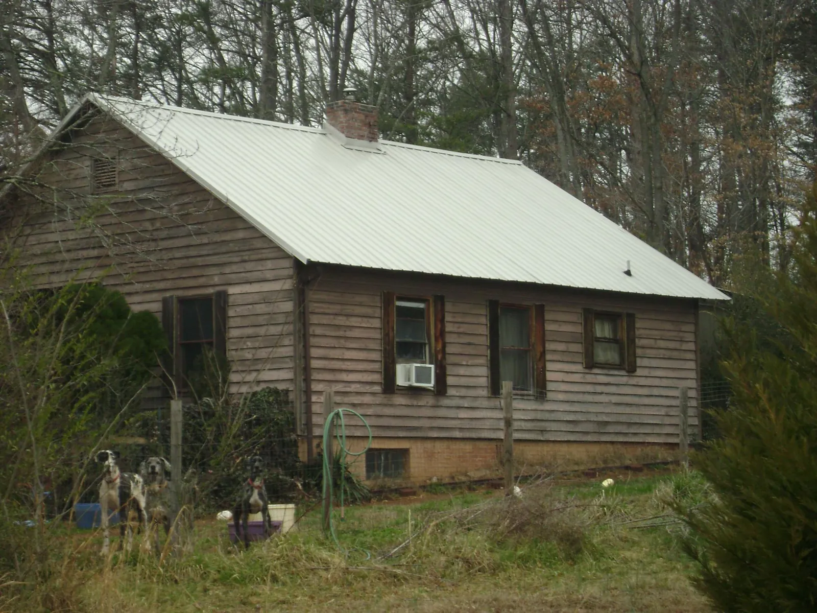 White metal roof on an old wood sided farmhouse, from a Metal Roof Installation job in Bakersville
